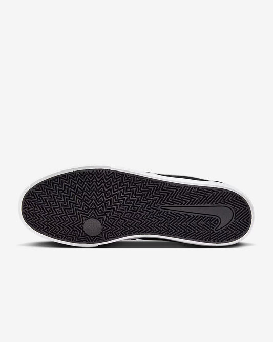 Sole view of black and white Nike SB Charge Canvas sneaker showing herringbone tread pattern on white background