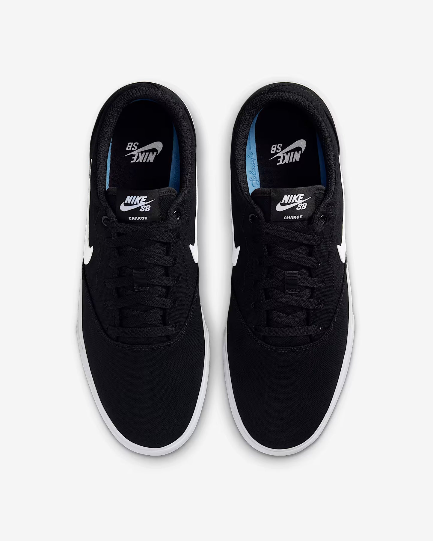 Top view of black Nike SB Charge Canvas sneakers with white swoosh logos and blue insole accents on white background
