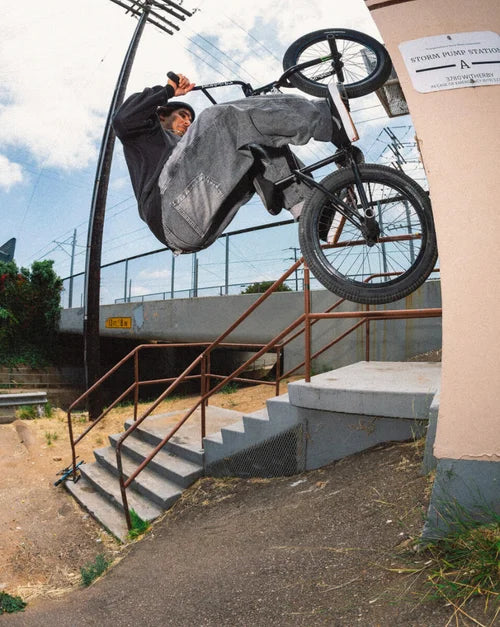 Rider performing a BMX trick wearing black BMX Old Skool shoes on a staircase with rails